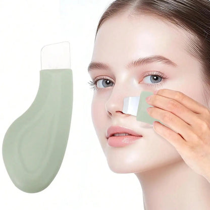 Person applying a green facial mask to their face with a white applicator.